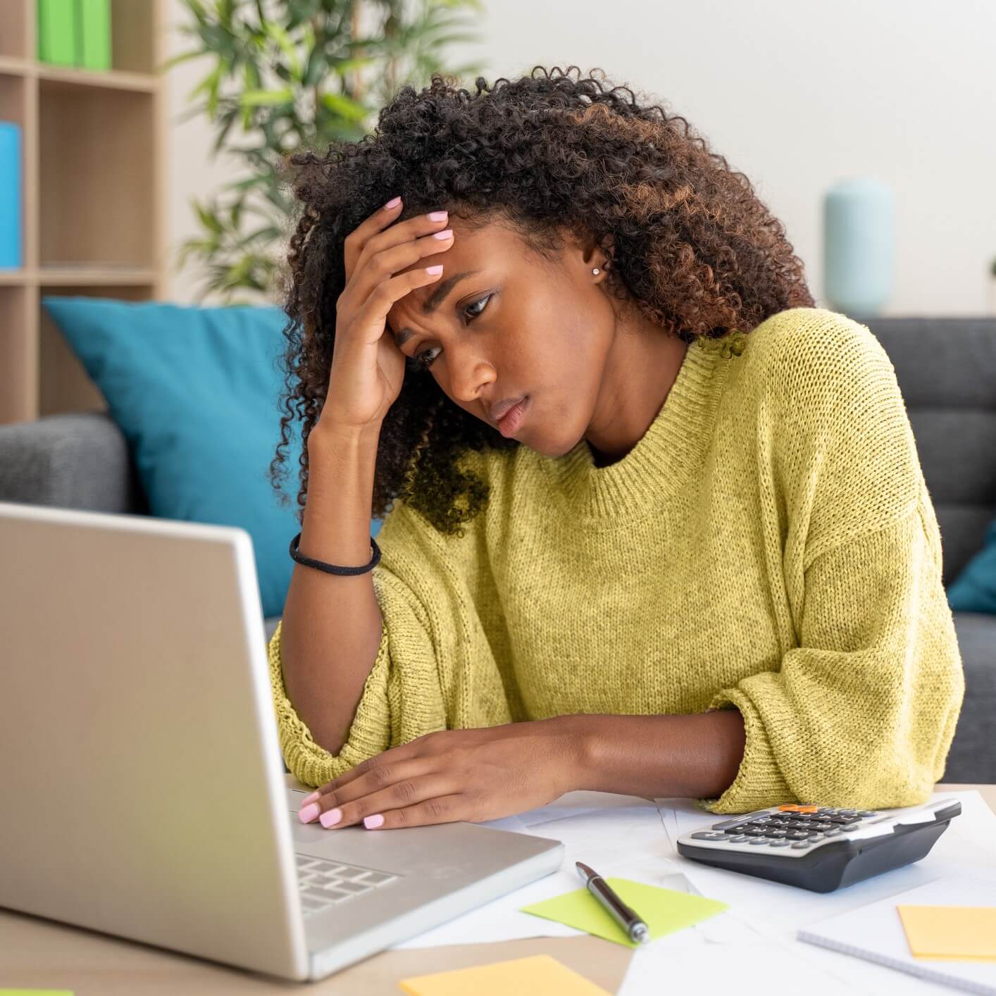 woman looking frustrated while looking at a laptop