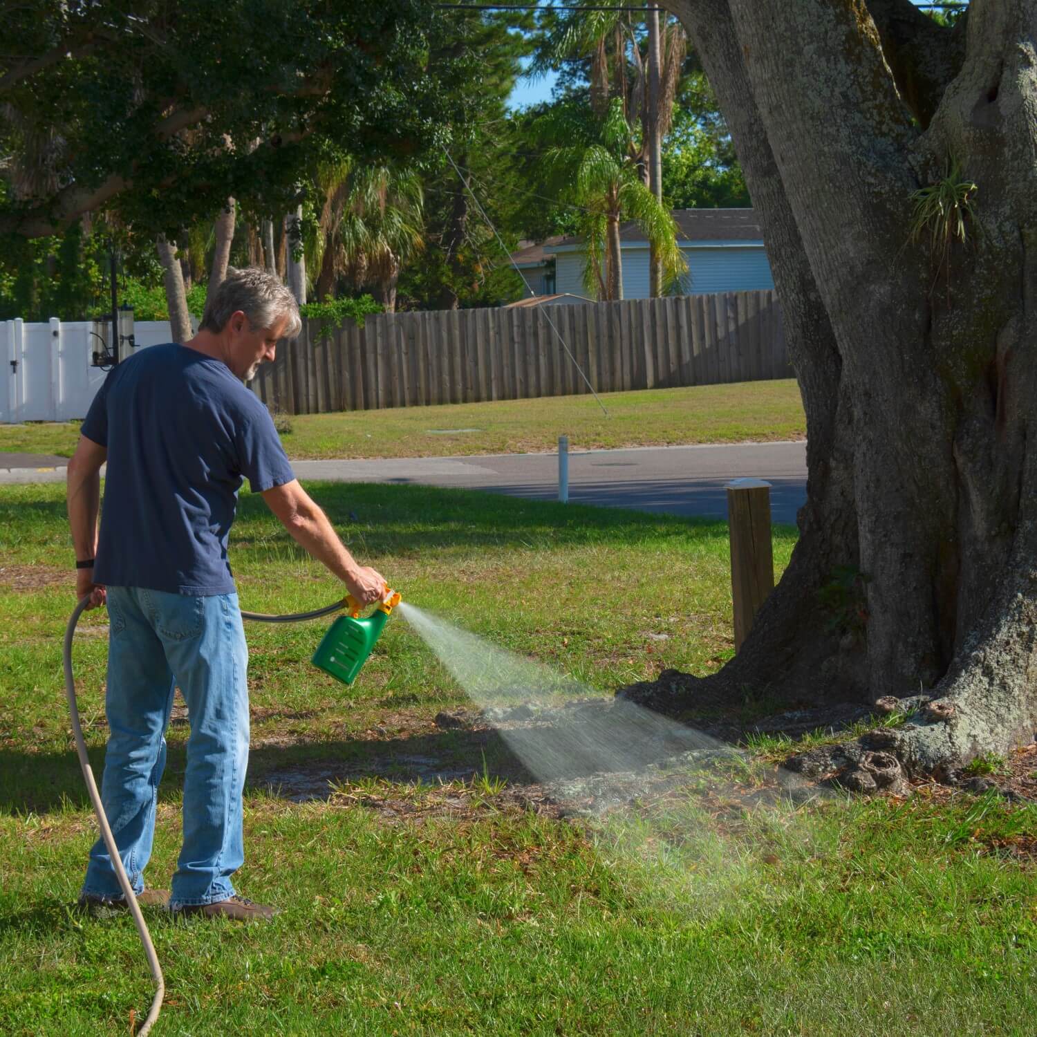 man spraying weed killer in yard